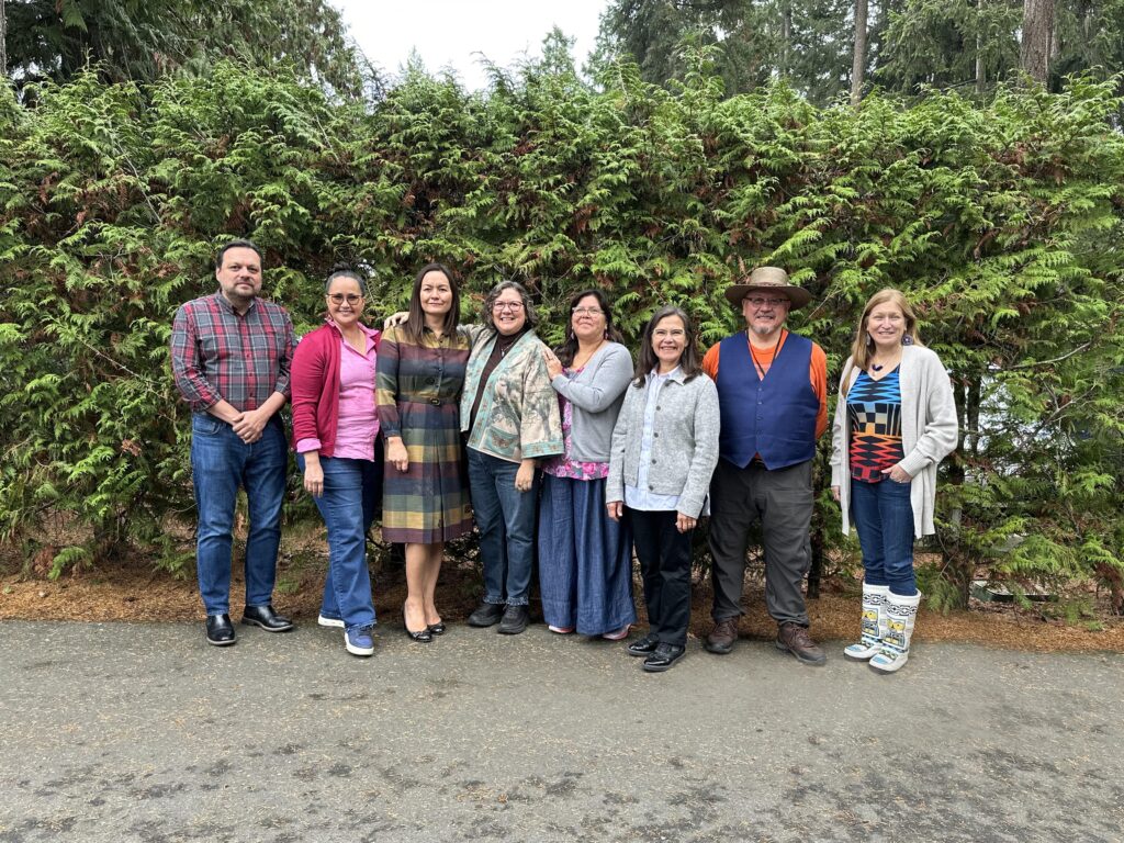 Group of the eight of the FPCC Board members standing together in front of a cedar hedge at the FPCC AGM 2023.
