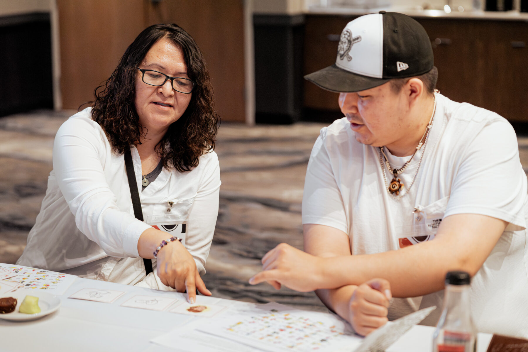 Mother and son looking at language resources and talking with each other at the FPCC Mentor-Apprentice Program training