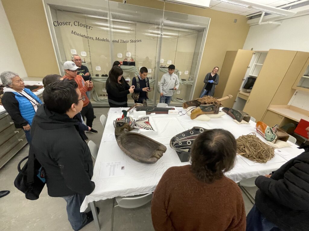 People sitting around a table full of cultural belongings