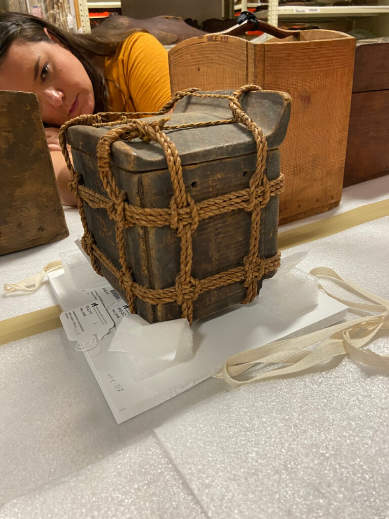 Lindsey viewing a wooden storage box wrapped in cedar rope